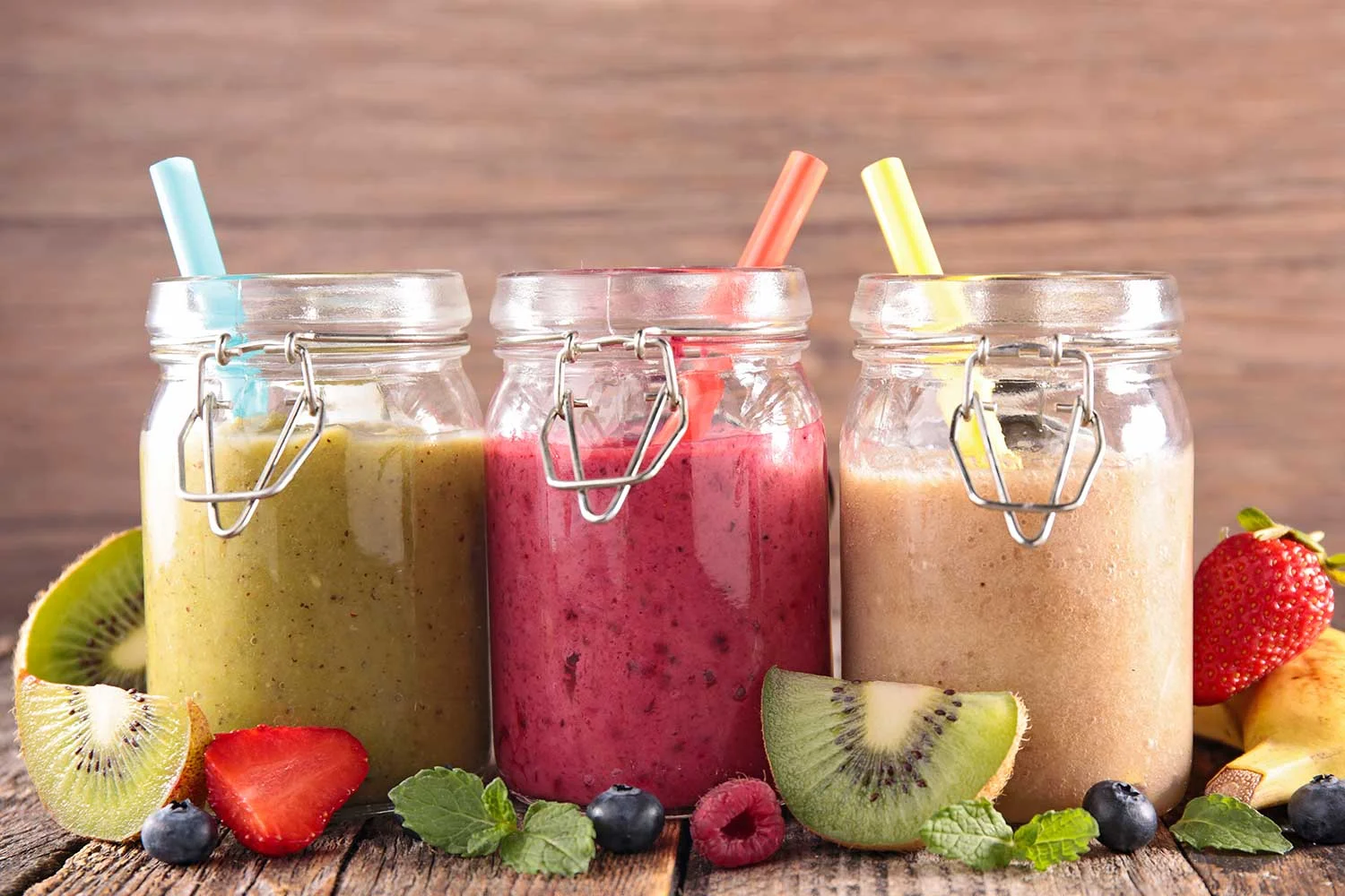 Three mugs of ketogenic smoothie drinks with fruits.