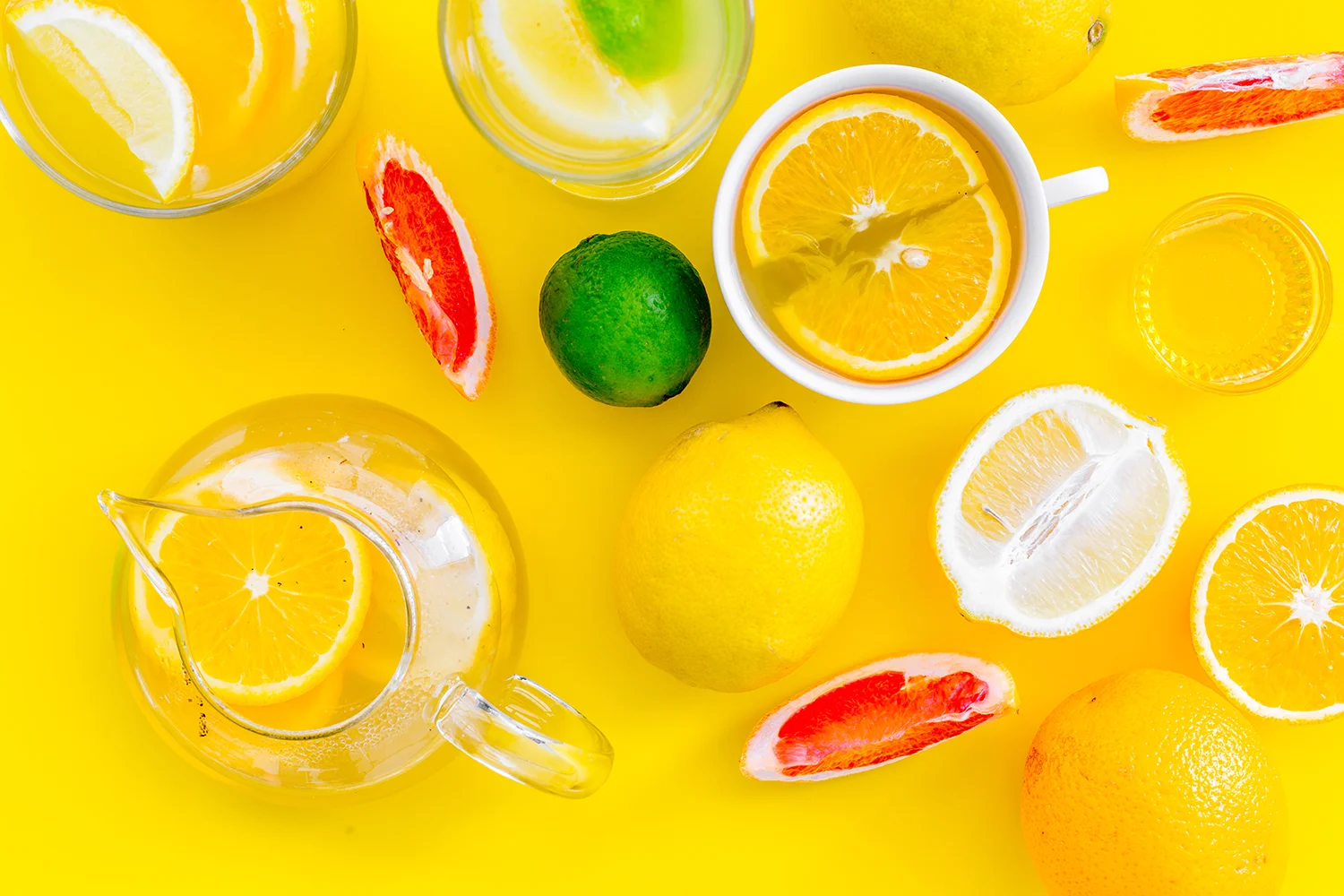 lemonade drink with lemon, lime, grapefruit on yellow background