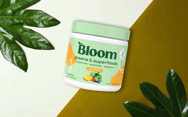 Bloom nutrition super green powder on leafy background