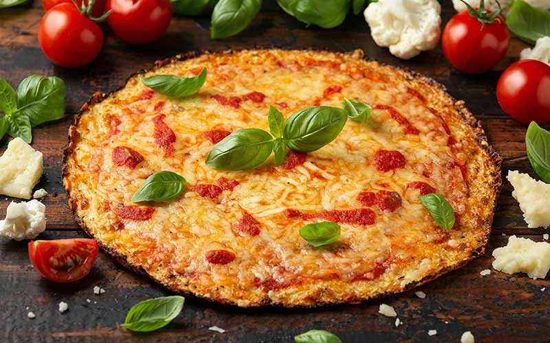Cauliflower crust pizza with tomato sauce, cheese and basil. Healthy diet food.