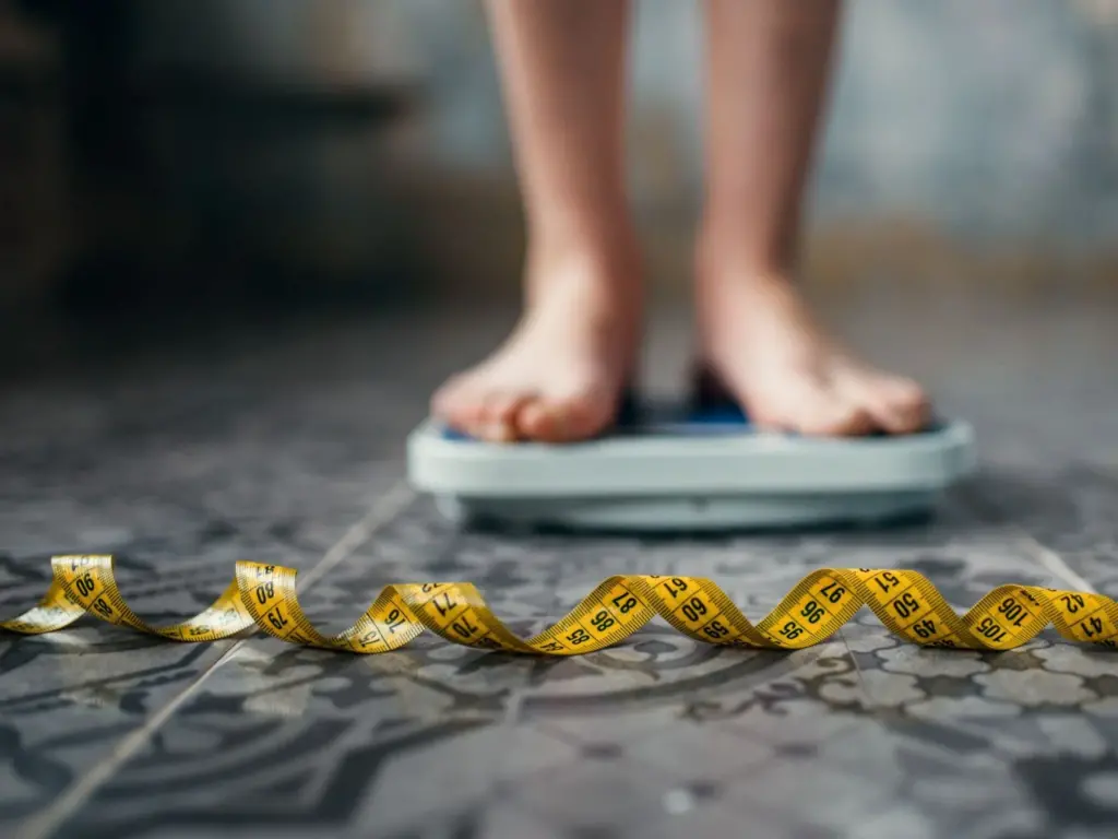 A person on the scales, measuring tape