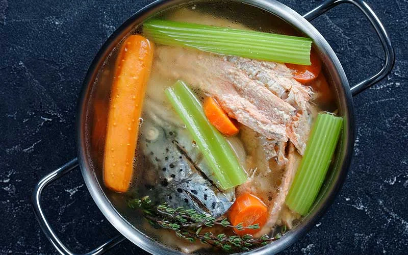 bone broth with carrots, celery in kitchen