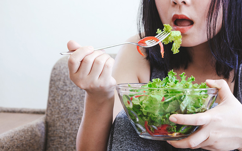 Lady eating vegetable salad
