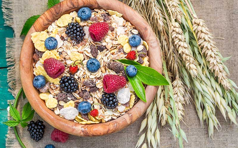 Healthy breakfast with muesli and fresh berries on a rustic background.