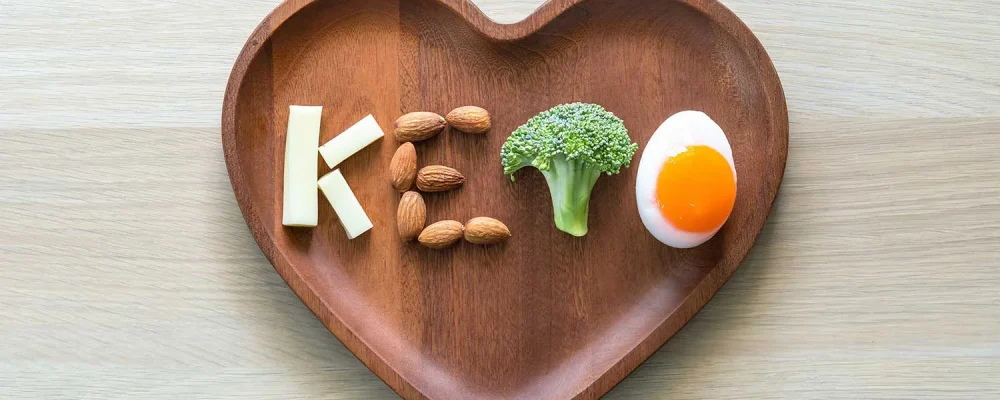 Keto food for ketogenic diet on a heart shaped wooden plate.