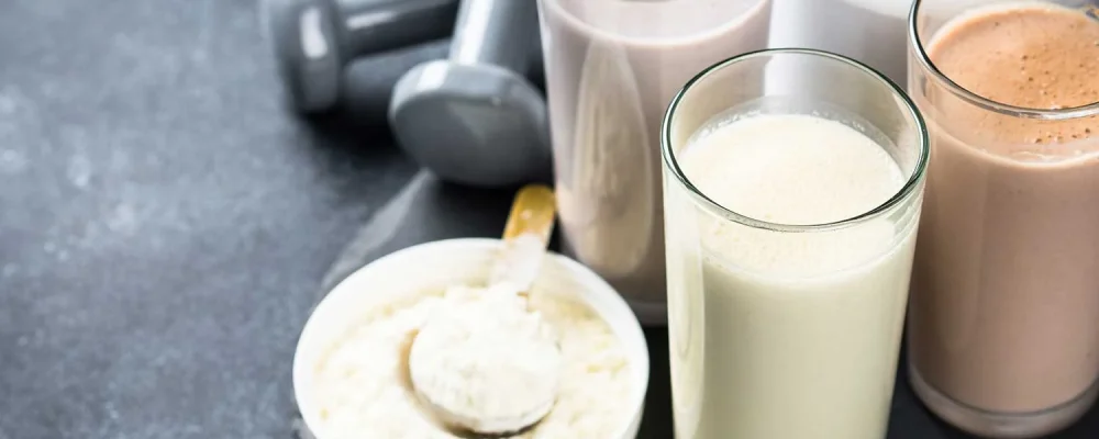 Healthy meal replacement shakes with protein powder, dumbbells and powder.