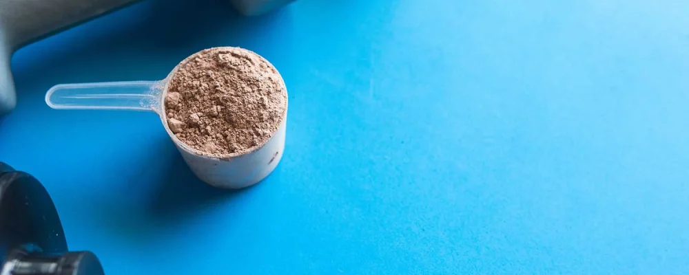 Dumbbells and superfood powder on blue background