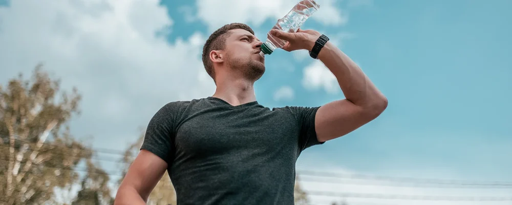 A man is drinking water from a bottle