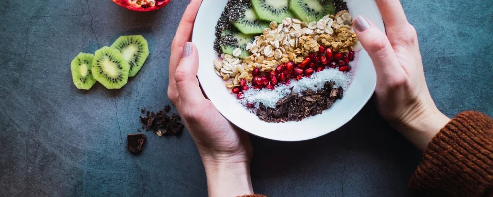 Woman holding a smoothie bowl with superfoods and fruits